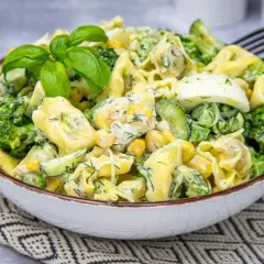 Pyszna sałatka z tortellini, brokułów, kukurydzy, ogórka i jajka w kremowym sosie.