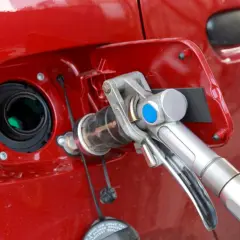 Remplissage d'une voiture rouge avec un pistolet GPL. Avis sur la bicarburation essence/GPL.