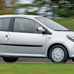 Srebrne Renault Twingo 2 w ruchu, z rozmytym tłem zieleni i drzew.