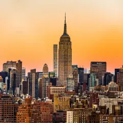 Widok na panoramę Nowego Jorku z Empire State Building w zachodzącym słońcu.