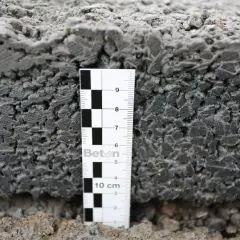 Nahaufnahme eines stampfbeton fundaments mit einer Messlatte, die die Schichten und Textur zeigt.