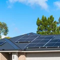 Pannelli solari sul tetto di una casa, con alberi sullo sfondo. Si valuta il collegamento pannelli solari in serie o parallelo per massimizzare l'energia.