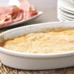 Gateau di patate pronto per essere gustato, preparato con il Bimby. Sullo sfondo, affettati e formaggio.