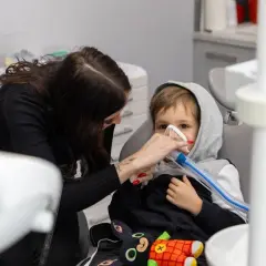 Chłopiec w masce znieczulającej u dentysty. Po zabiegu nie można jeść, by uniknąć zadławienia.
