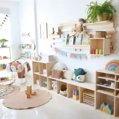 Una acogedora zona de juegos para niños, llena de juguetes de madera, libros y peluches, invita a la imaginación y al aprendizaje.