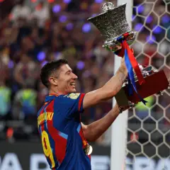 Robert Lewandowski z pucharem, symbol jego bogatej kariery. Krótka biografia tego piłkarza to historia sukcesów.