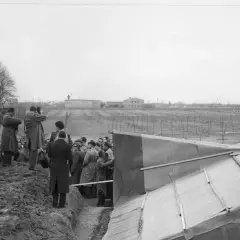 Eine Gruppe von Männern, darunter viele mit Kameras, versammelt sich um eine ausgegrabene Struktur. Ein Fall von Spionage im Kalten Krieg?