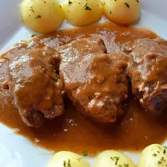 Carrilleras al vino tinto, tiernas y jugosas, bañadas en una rica salsa, acompañadas de patatas cocidas.