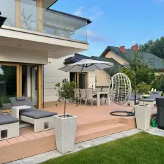 Nowoczesne ogród aranżacje: taras z leżakami, stołem i krzesłami, huśtawka, jacuzzi.