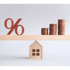 Bilancia con simbolo percentuale e pile di monete su una casa. Un'illustrazione su come comprare una casa.