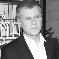 Krzysztof Reszpondek, znany z walki z chorobą, na tle neonowego napisu.