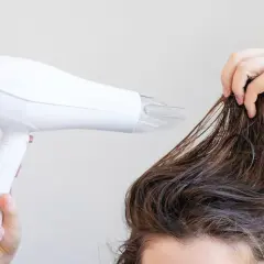 Secando el pelo mojado con un secador para dar volumen al pelo fino.