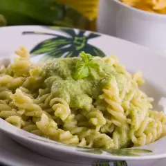 Fusilli z kremowym, zielonym sosem z cukinii, udekorowane listkiem bazylii. Pyszny sos z cukinii do makaronu.