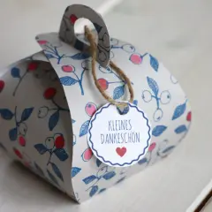 Eine liebevoll gestaltete DIY Geschenkbox mit Beerenmuster und dem Anhänger "Kleines Dankeschön".