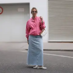 Modna stylizacja z jeansową spódnicą maxi i różową kurtką. Kobieta w okularach przeciwsłonecznych i torebce z kolorowym wzorem.