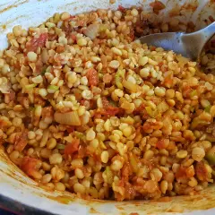 En skål med kryddig chana dal, en indisk linsrätt med tomat och lök, redo att serveras.