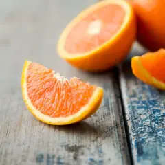 Arance fresche tagliate a spicchi su un tavolo di legno. Quante arance si possono mangiare al giorno per un pieno di vitamina C?