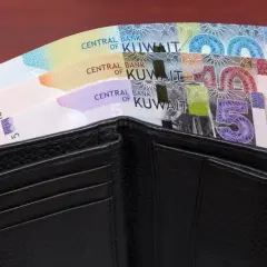 Czarny portfel z banknotami dinara kuwejckiego. Czy to najdroższa waluta świata?