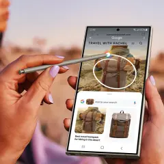 Dłoń z rysikiem S Pen używa funkcji Samsung Galaxy AI do wyszukiwania plecaka podróżnego na telefonie.