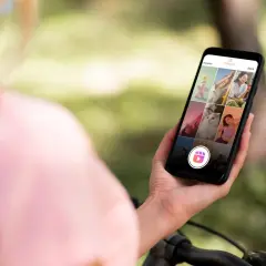 Osoba trzyma smartfon z widokiem na ekran Instagram Reels z różnymi zdjęciami.