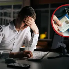 Zmartwiony mężczyzna przy komputerze, w dłoniach pieniądze. Czy wypowiedzenie za porozumieniem stron a urlop to dobry pomysł?