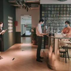 Kobieta w masce na telefonie, mężczyzna przy ladzie, pracownica biura. Czy imię i nazwisko to RODO? Dystans społeczny.