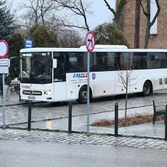 Biały autobus FASTER z Olsztyna, gotowy do kursu. Może właśnie jedzie po bilet miesięczny dla pasażerów.