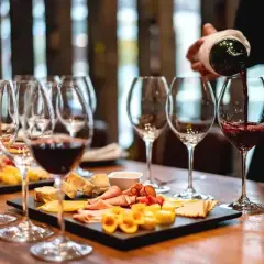 Une dégustation de vin à Paris, avec des verres remplis de vin rouge et des plateaux de fromages et charcuteries.