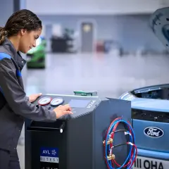 Mekaniker utför service på en Ford Focus. Maskinen indikerar att det är dags för ford focus serviceintervall.