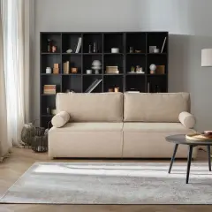 Przytulny salon z beżową kanapą i czarną biblioteczką. Gotowe aranżacje wnętrz, które inspirują do stworzenia własnej, stylowej przestrzeni.