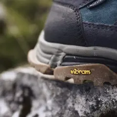 Nahaufnahme eines Wanderschuhs mit Vibram-Sohle auf einem Stein. Mögliche vibram sohle nachteile wie Abnutzung sind hier nicht sichtbar.