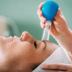 Zabieg z użyciem baniek na zatoki. Terapia próżniowa poprawia krążenie i pomaga udrożnić zatoki.