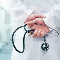 Mani di un medico con stetoscopio dietro la schiena, forse riflettendo su dimissioni dirigente medico e ferie non godute.