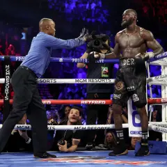 Referee stops the fight, signaling the end. Deontay Wilder stands, exhausted but victorious, as the crowd roars.