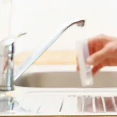 Test paskowy do wody i ręka nalewająca wodę z kranu do probówki. Jak sprawdzić twardość wody?