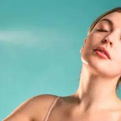 Une femme reçoit une brume rafraîchissante sur le visage. Une brume sert à hydrater et revitaliser la peau.