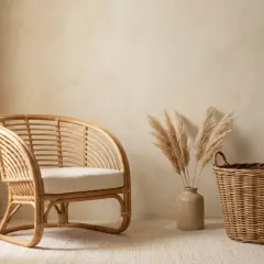 Un fauteuil en rotin naturel, un panier tressé et des herbes de pampa dans un vase. L'idée de peindre du rotin pour un look différent.
