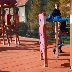 Plac zabaw w Przytkowicach z kolorowymi zjeżdżalniami i drabinkami. Dzieci bawią się na świeżym powietrzu.