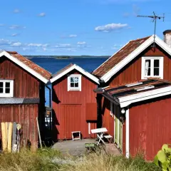 Röda stugor vid vattnet, en idyllisk vy från Sandhamn camping.