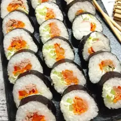 Gotowe sushi z łososiem, tuńczykiem i warzywami. Prosty sposób, jak zawinąć sushi, by wyglądało apetycznie.