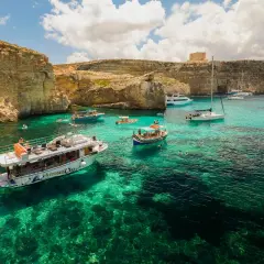 Malta, wrzesień: turkusowa woda, klify i łodzie w Zatoce Błękitnej. Idealna pogoda na rejs.