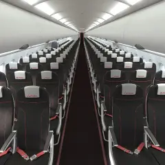 Wnętrze samolotu linii lotniczych Electra Airways. Rzędy czarnych foteli z czerwonymi przeszyciami i białymi zagłówkami z logo ITAKA.