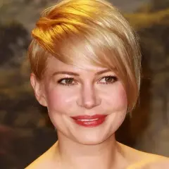 Kobieta z okrągłą twarzą i stylową, krótką fryzurą w odcieniu blondu.
