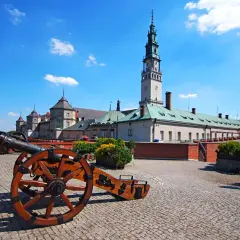 Jasne niebo nad największym sanktuarium w Polsce. Przed nim zabytkowe armaty na brukowanym dziedzińcu.