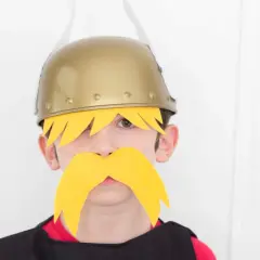 Niño con disfraz casero de Astérix y Obélix, luciendo casco dorado y bigote amarillo.