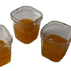 Trois petits pots en verre remplis d'un liquide ambré, prêts à être consommés comme gel énergétique maison.