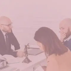 Trzech prawników przy biurku, jeden zasłania usta.