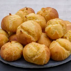 Pile de gougères dorées et gonflées, parfaites pour apprendre comment faire gonfler des gougères.
