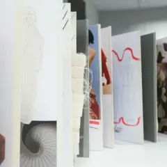 Un acheteur textile parcourt des croquis de mode, des échantillons de tissu et des motifs, imaginant de futures collections.