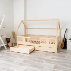 Łóżko domek z litego drewna sosnowego, z szufladami, obok regał, bębny i gitara.